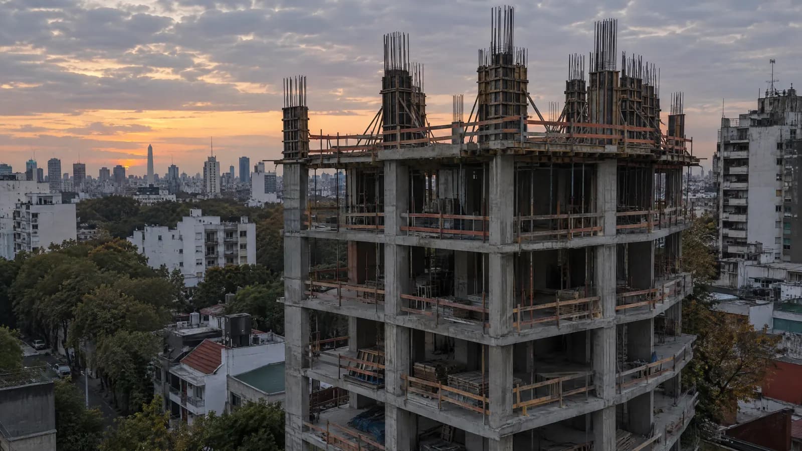 Estructura de hormigón de un edificio en construcción al anochecer.