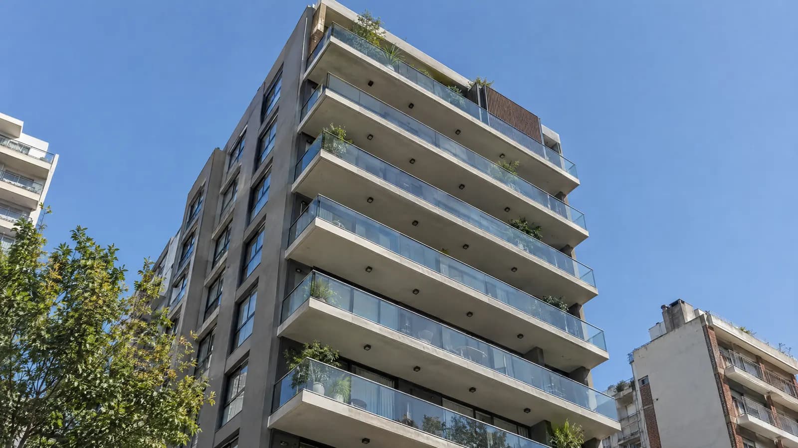 Edificio residencial moderno con balcones de vidrio contra el cielo de Núñez.